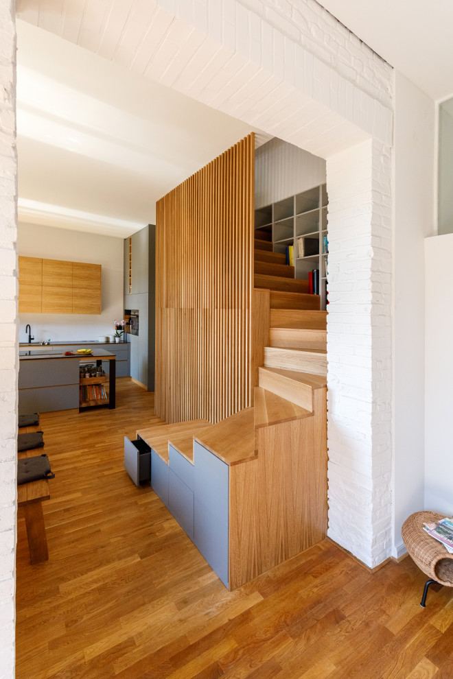 Ejemplo de escalera curva contemporánea con escalones de madera, contrahuellas de madera, barandilla de madera y madera