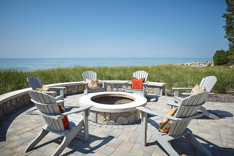Photo of a large beach style backyard patio in Grand Rapids with a fire feature, concrete pavers and no cover.