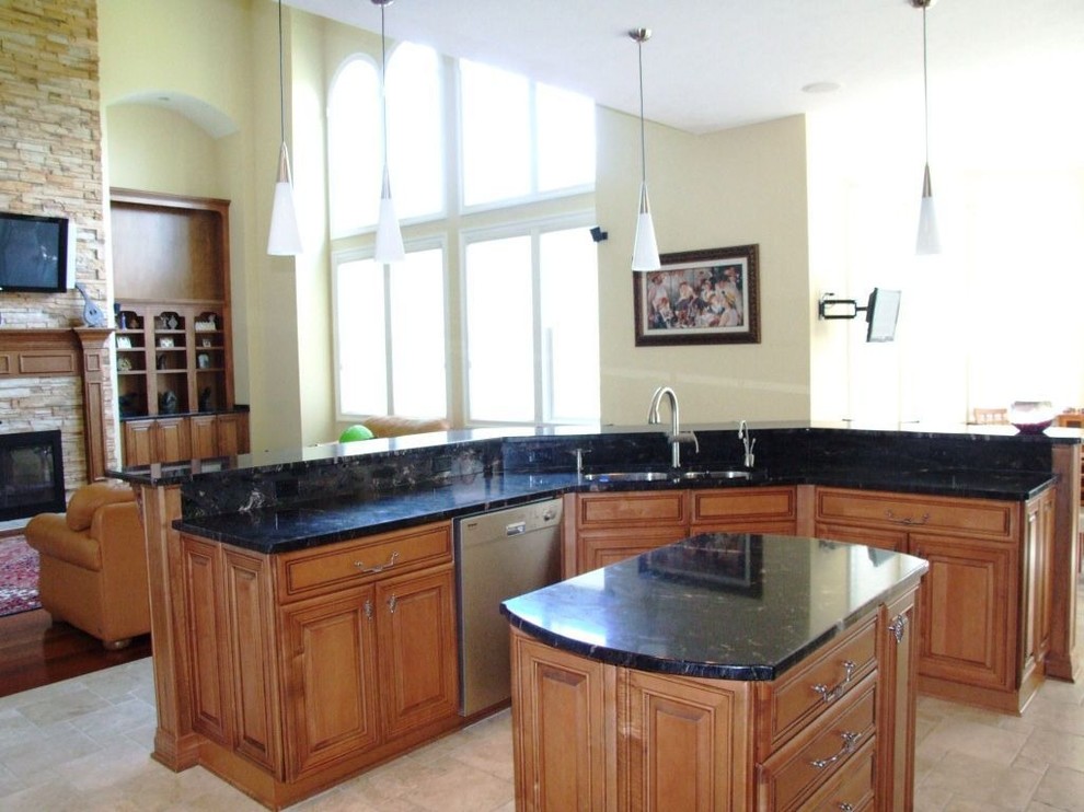This is an example of a mid-sized traditional eat-in kitchen in Atlanta with an undermount sink, raised-panel cabinets, light wood cabinets, granite benchtops, black splashback, stainless steel appliances, ceramic floors and multiple islands.