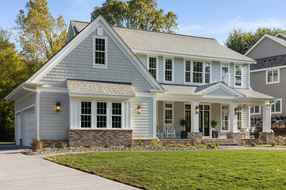 Photo of a large traditional two-storey grey house exterior in Minneapolis with a gable roof, a shingle roof and concrete fiberboard siding.