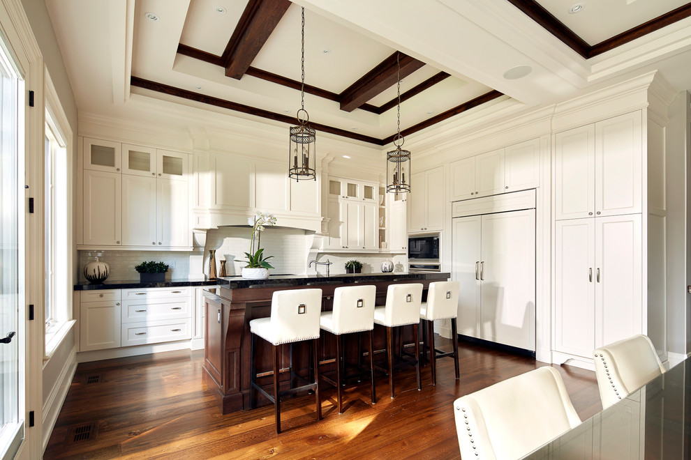 Inspiration for a large transitional l-shaped medium tone wood floor open concept kitchen remodel in Toronto with recessed-panel cabinets, white cabinets, granite countertops, white backsplash, subway tile backsplash, stainless steel appliances and an island