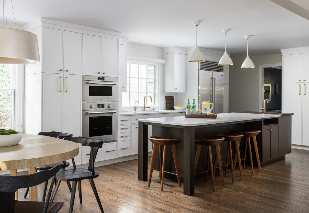 Kitchen - large transitional medium tone wood floor and brown floor kitchen idea with an undermount sink, shaker cabinets, white cabinets, quartz countertops, stainless steel appliances, an island and white countertops