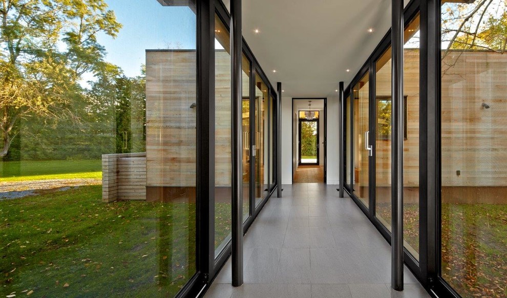 This is an example of a large contemporary hallway in Toronto with porcelain floors and white walls.