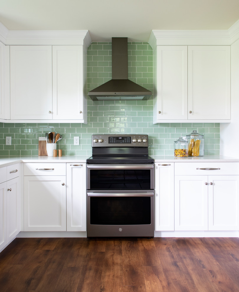 Kitchen - transitional vinyl floor kitchen idea with an undermount sink, shaker cabinets, white cabinets, quartz countertops, green backsplash, glass tile backsplash, stainless steel appliances, no island and white countertops