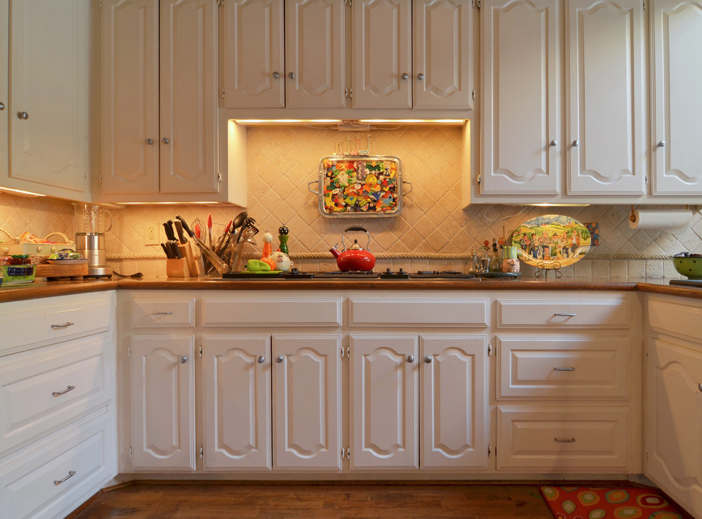 Design ideas for an eclectic u-shaped kitchen in Dallas with raised-panel cabinets, white cabinets and wood benchtops.
