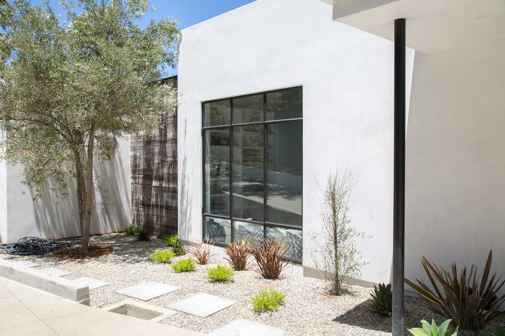 Photo of a transitional one-storey adobe white house exterior in Los Angeles with a flat roof.