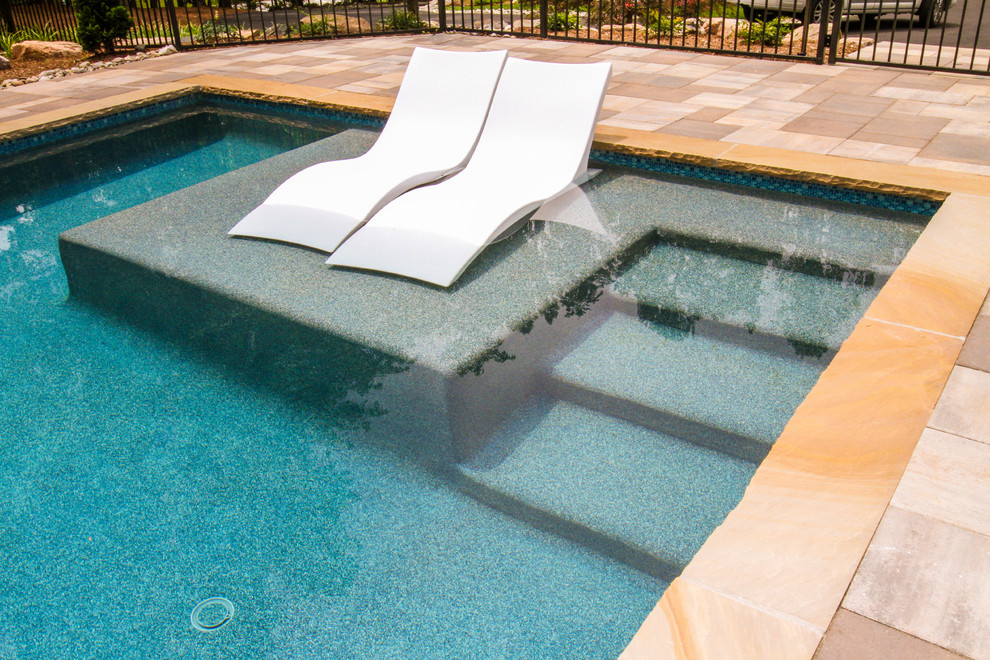 Large arts and crafts side yard rectangular lap pool in Other with a pool house and natural stone pavers.