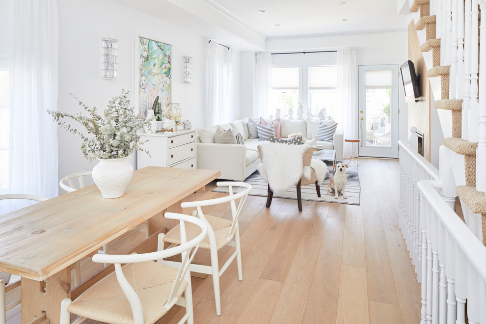 Small scandinavian dining room in Other with white walls, light hardwood floors, a standard fireplace, a wood fireplace surround and white floor.