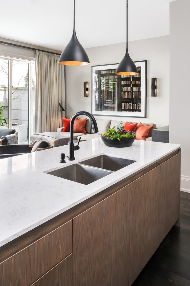 Design ideas for a mid-sized transitional open plan kitchen in Toronto with an undermount sink, flat-panel cabinets, medium wood cabinets, black appliances, dark hardwood floors, with island, quartz benchtops and white benchtop.