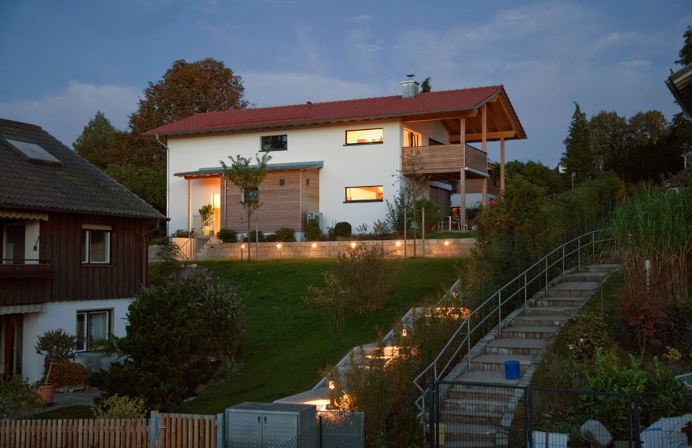 Großes, Zweistöckiges Modernes Haus mit Mix-Fassade, weißer Fassadenfarbe, Satteldach, Ziegeldach und rotem Dach in München
