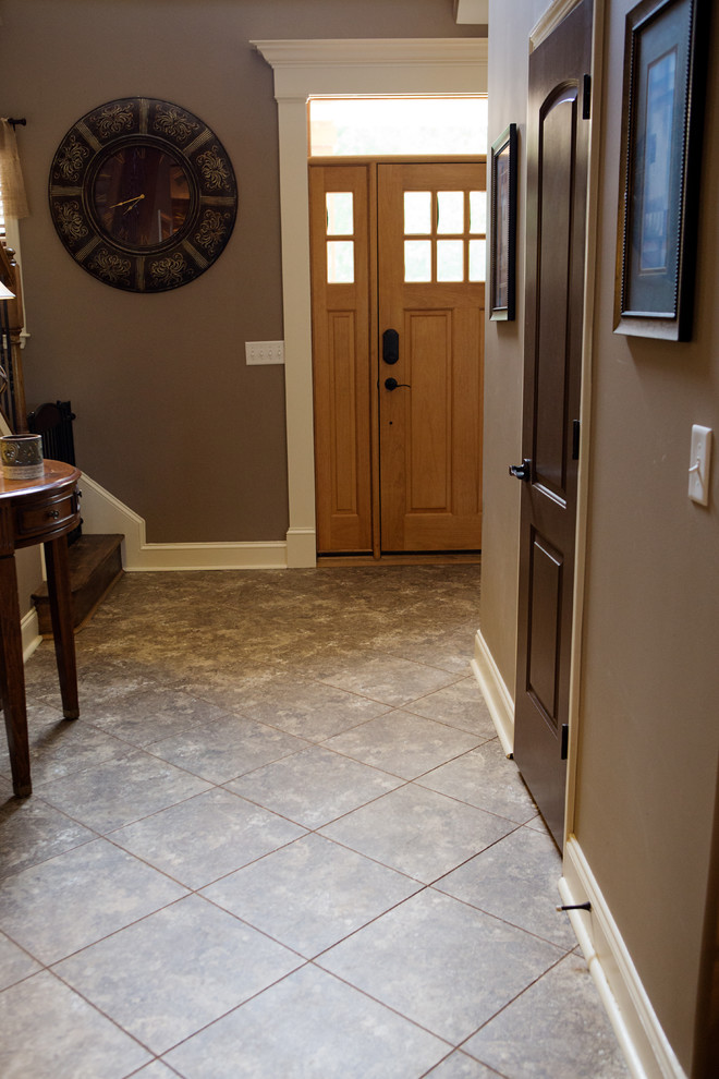 Example of a mid-sized transitional vinyl floor foyer design with brown walls and a light wood front door