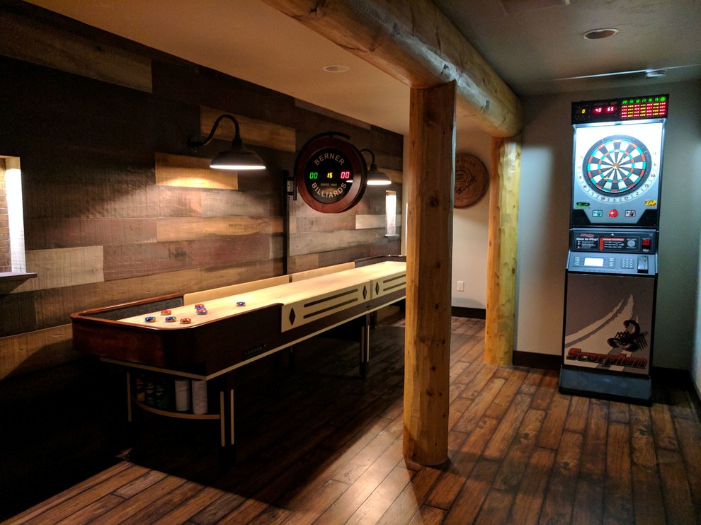 Large mountain style underground medium tone wood floor and brown floor basement game room photo with gray walls and no fireplace