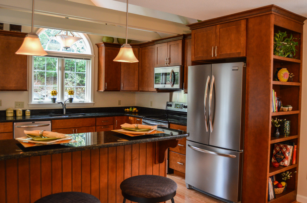 Inspiration for a mid-sized transitional l-shaped light wood floor open concept kitchen remodel in Charleston with an undermount sink, recessed-panel cabinets, medium tone wood cabinets, granite countertops, stainless steel appliances and a peninsula