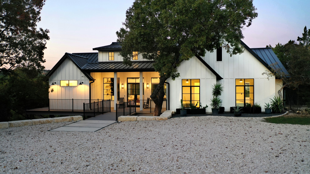 Exemple d'une façade de maison blanche nature en panneau de béton fibré et planches et couvre-joints de taille moyenne et de plain-pied avec un toit à deux pans, un toit en métal et un toit noir.