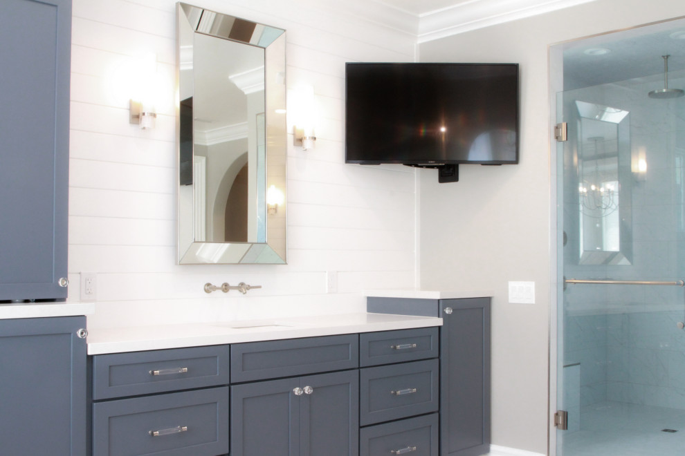 Photo of a large beach style master bathroom in Los Angeles with blue cabinets, a freestanding tub, an alcove shower, a one-piece toilet, white tile, beige walls, a drop-in sink, engineered quartz benchtops, yellow floor, an open shower, white benchtops, a shower seat, a single vanity, a built-in vanity and planked wall panelling.