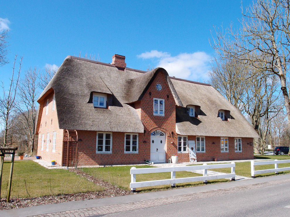 Geräumiges, Dreistöckiges Landhaus Haus mit Backsteinfassade, roter Fassadenfarbe und Satteldach in Sonstige