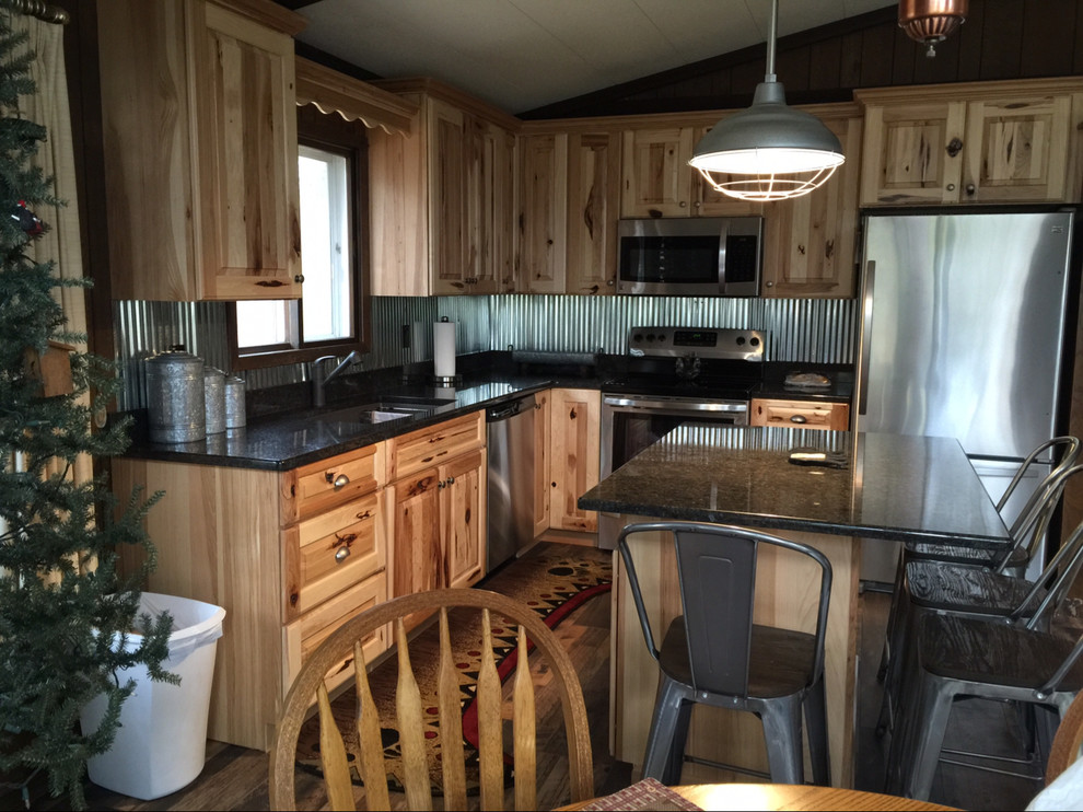 Example of a small eclectic l-shaped eat-in kitchen design with an undermount sink, raised-panel cabinets, granite countertops, stainless steel appliances and an island