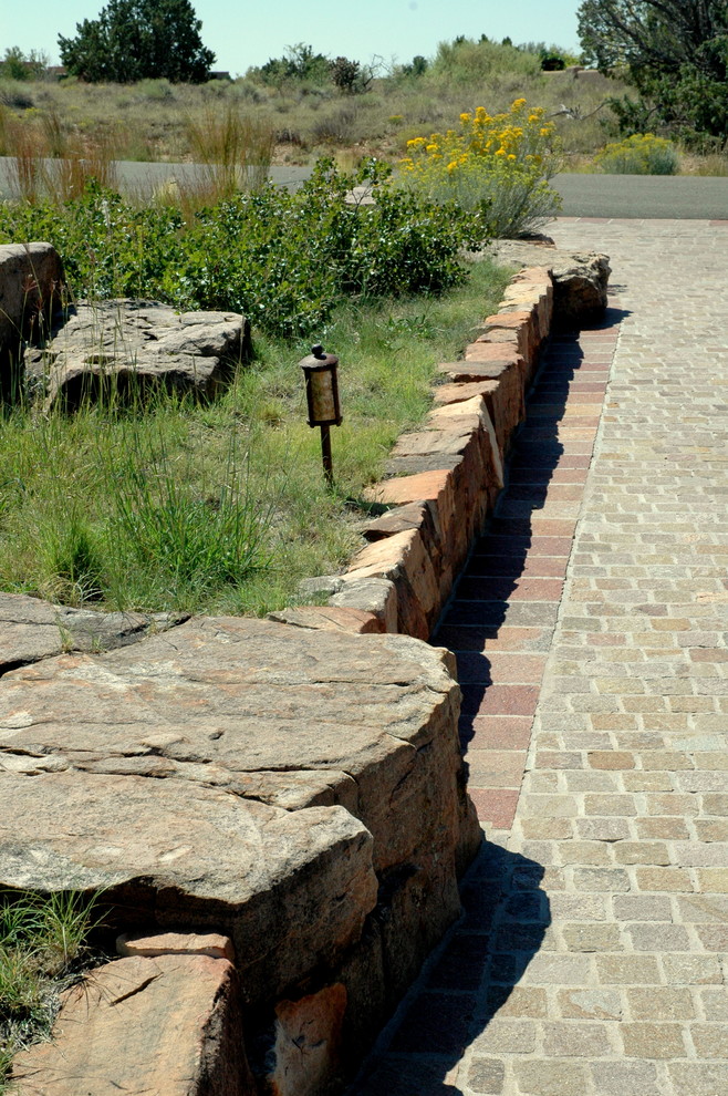 Inspiration for a large traditional full sun garden in Albuquerque with a retaining wall and natural stone pavers.