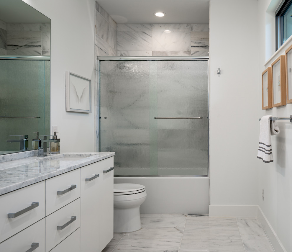 Medium sized contemporary family bathroom in Austin with flat-panel cabinets, white cabinets, an alcove bath, a shower/bath combination, a two-piece toilet, white tiles, ceramic tiles, white walls, ceramic flooring, a submerged sink, quartz worktops, multi-coloured floors, a sliding door, multi-coloured worktops, a single sink and a built in vanity unit.