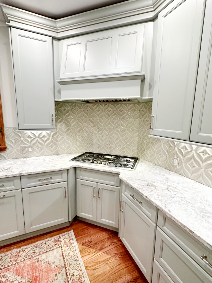 Inspiration for a transitional l-shaped medium tone wood floor eat-in kitchen remodel with shaker cabinets, green cabinets, quartzite countertops, porcelain backsplash, paneled appliances and an island