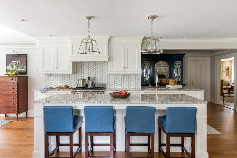 Photo of a beach style kitchen in Boston with an undermount sink, shaker cabinets, white cabinets, multi-coloured splashback, stainless steel appliances, medium hardwood floors, with island and multi-coloured benchtop.