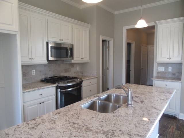 Mid-sized transitional dark wood floor eat-in kitchen photo in Jackson with an undermount sink, raised-panel cabinets, white cabinets, granite countertops, ceramic backsplash, stainless steel appliances and an island