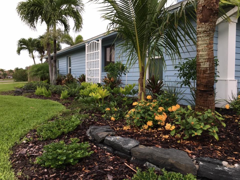 Photo of a mid-sized beach style front yard full sun garden in Orlando with a retaining wall.