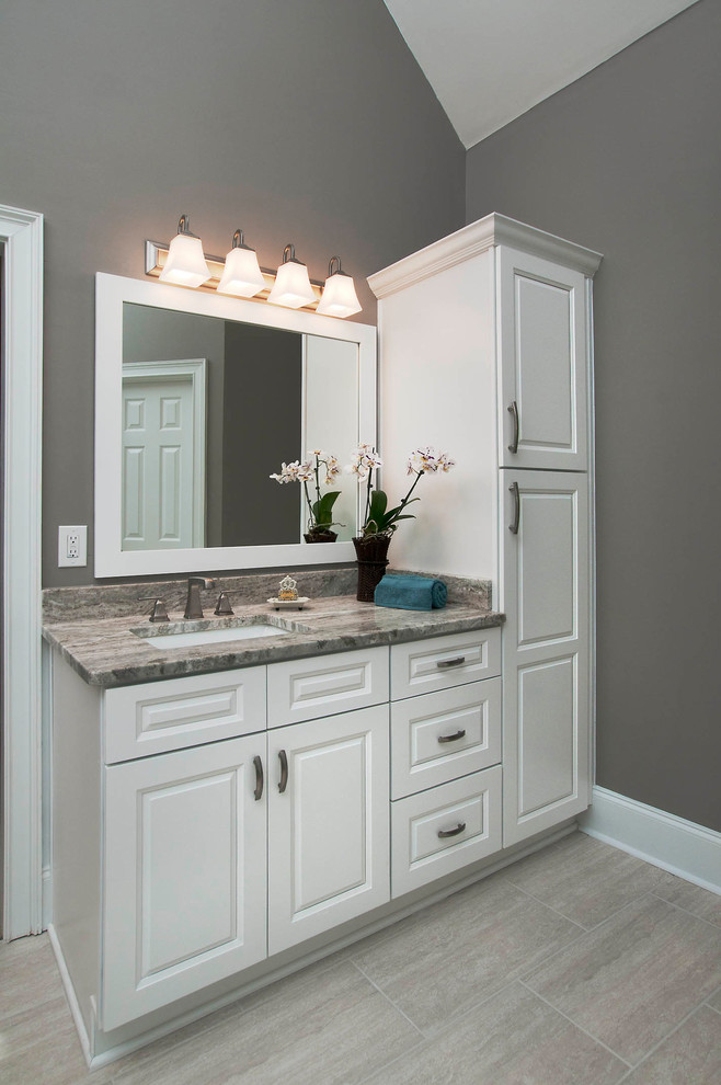 Inspiration for a large contemporary master bathroom in Atlanta with raised-panel cabinets, white cabinets, a drop-in tub, a corner shower, beige tile, porcelain tile, grey walls, an undermount sink, granite benchtops, beige floor, a hinged shower door and porcelain floors.