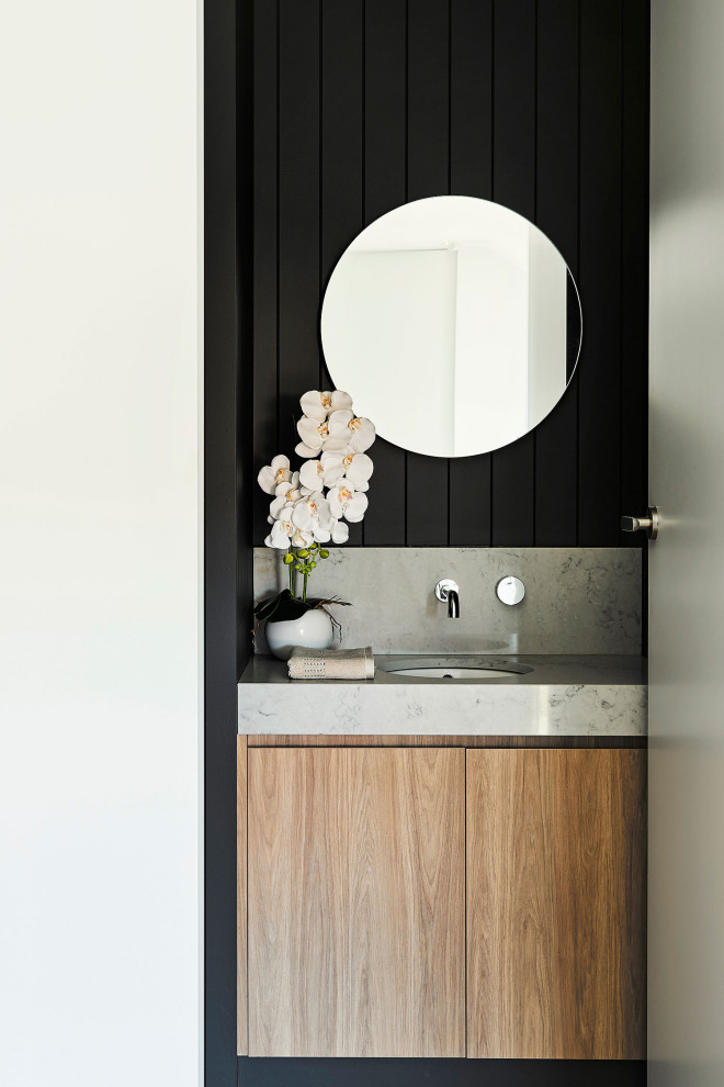 Mid-sized contemporary powder room in Geelong with black tile, black walls, medium hardwood floors, brown floor and a freestanding vanity.