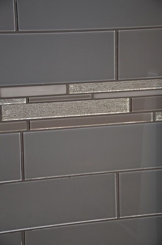 Mid-sized transitional u-shaped vinyl floor open concept kitchen photo in Toronto with an undermount sink, raised-panel cabinets, white cabinets, quartzite countertops, gray backsplash, glass tile backsplash, white appliances and a peninsula
