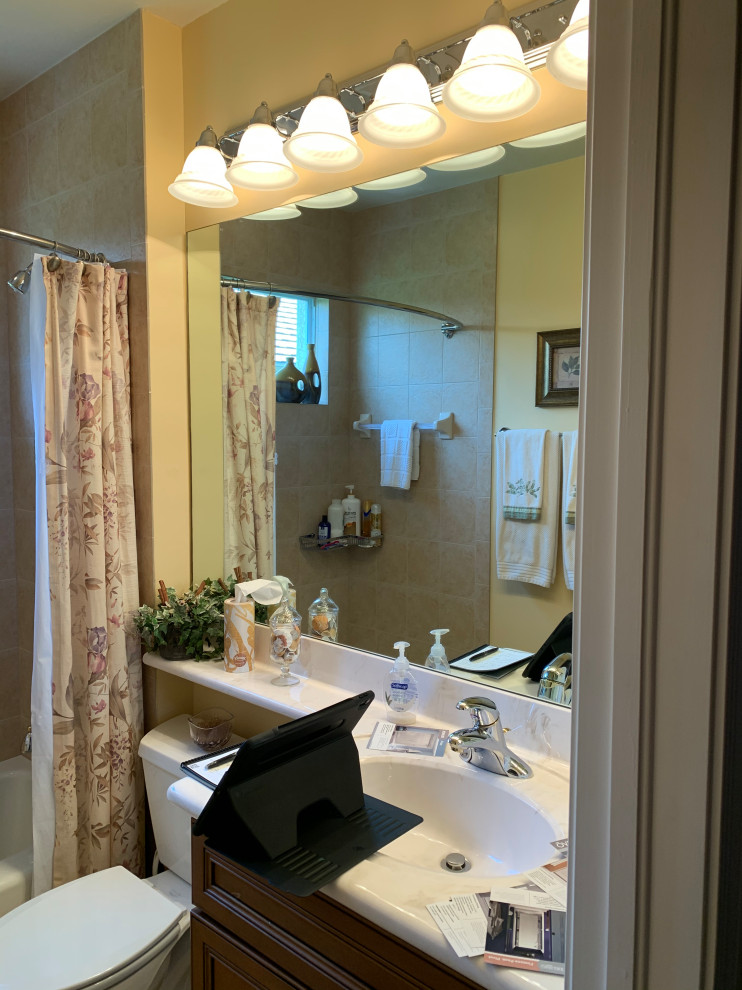 Small minimalist 3/4 brown tile and ceramic tile ceramic tile, beige floor and single-sink bathroom photo in Miami with recessed-panel cabinets, brown cabinets, a two-piece toilet, yellow walls, an integrated sink, solid surface countertops, beige countertops, a niche and a built-in vanity