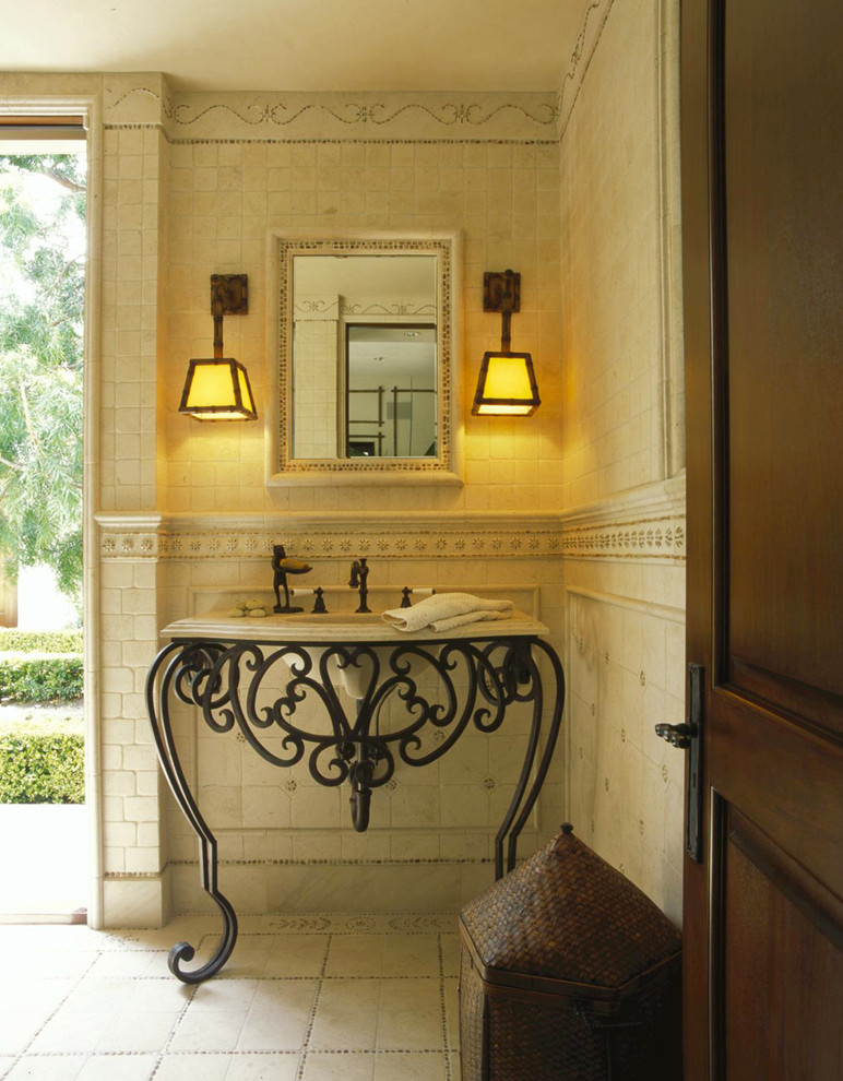 Photo of a traditional powder room in Orange County with an integrated sink, furniture-like cabinets, beige tile, limestone and beige benchtops.