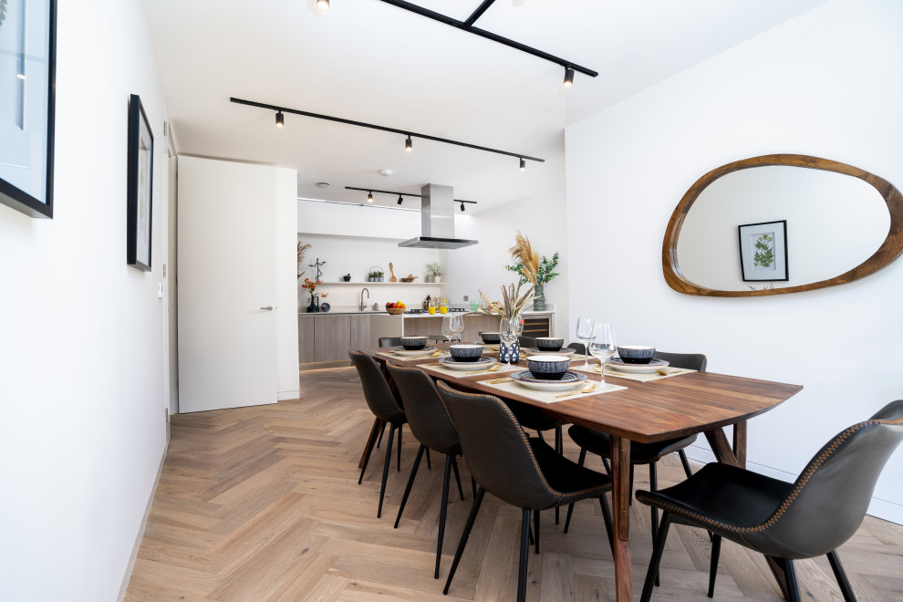 Cette image montre une salle à manger minimaliste de taille moyenne avec un sol en bois brun.