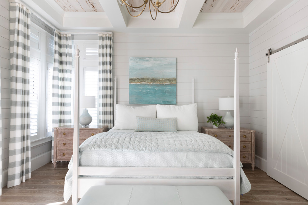 На фото: большая хозяйская спальня в морском стиле с белыми стенами, светлым паркетным полом, коричневым полом, кессонным потолком и стенами из вагонки без камина с