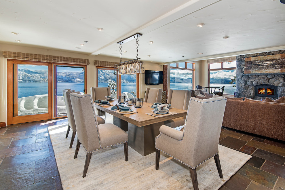 Great room - mid-sized transitional slate floor great room idea with beige walls, a wood stove and a stone fireplace