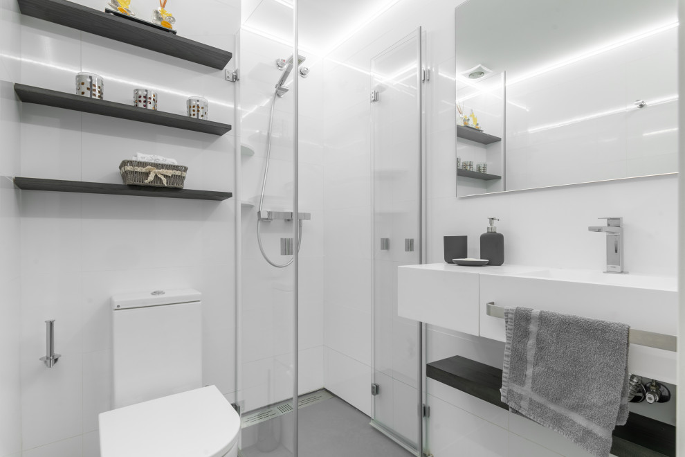 Small contemporary grey and white shower room bathroom in Barcelona with open cabinets, white cabinets, a built-in shower, a one-piece toilet, white tiles, ceramic tiles, white walls, ceramic flooring, an integrated sink, limestone worktops, grey floors, a hinged door, white worktops, a single sink and a built in vanity unit.