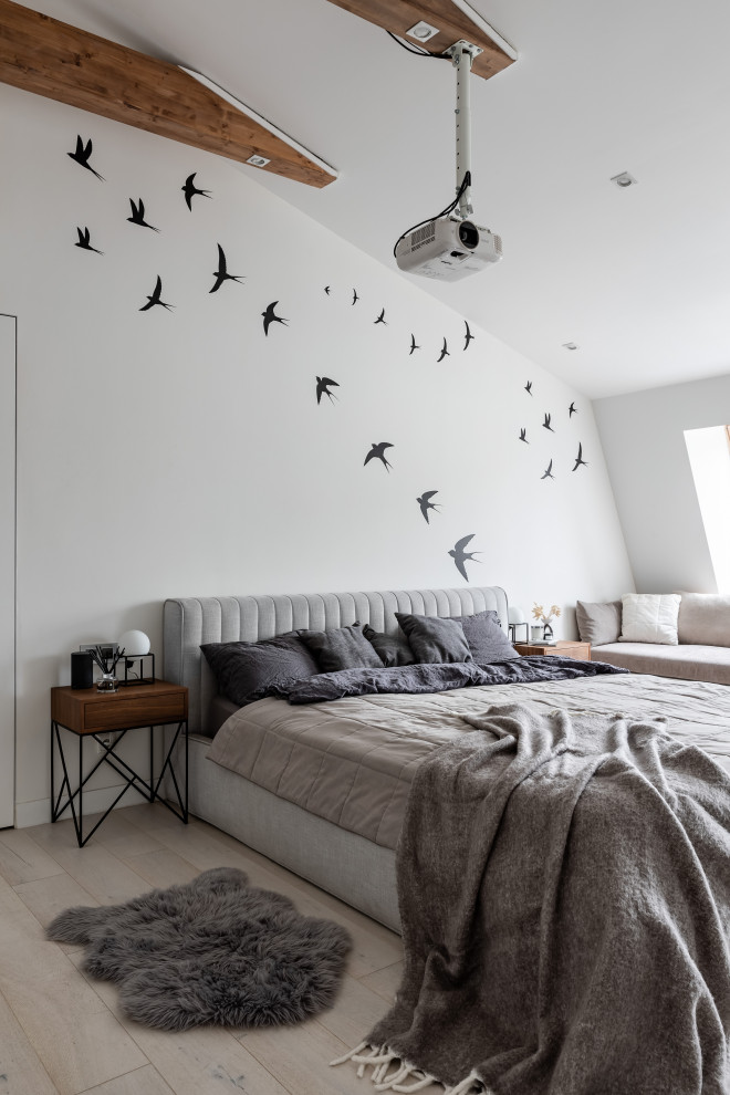 This is an example of a large scandinavian master bedroom in Saint Petersburg with white walls, light hardwood floors, beige floor and exposed beam.