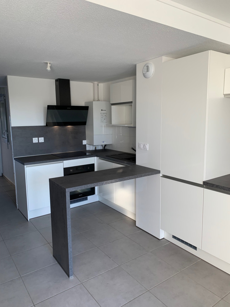 Photo of a large farmhouse grey and white l-shaped kitchen/diner in Toulouse with beaded cabinets, white cabinets, laminate countertops, grey splashback, stainless steel appliances, ceramic flooring, grey floors and grey worktops.