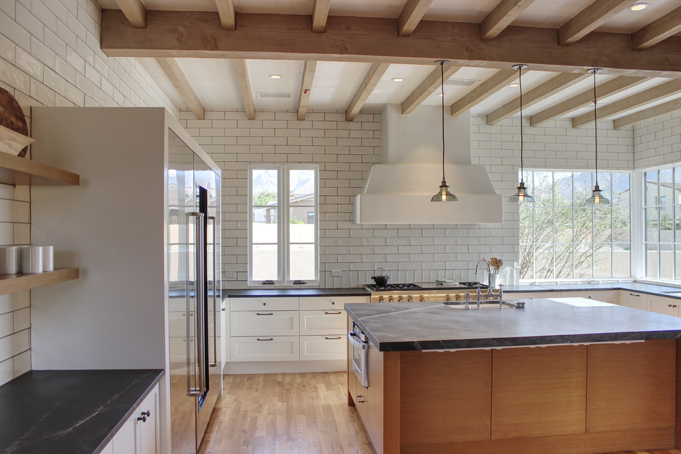 Large transitional u-shaped medium tone wood floor open concept kitchen photo in Phoenix with shaker cabinets, white cabinets, soapstone countertops, white backsplash, ceramic backsplash, stainless steel appliances and an island