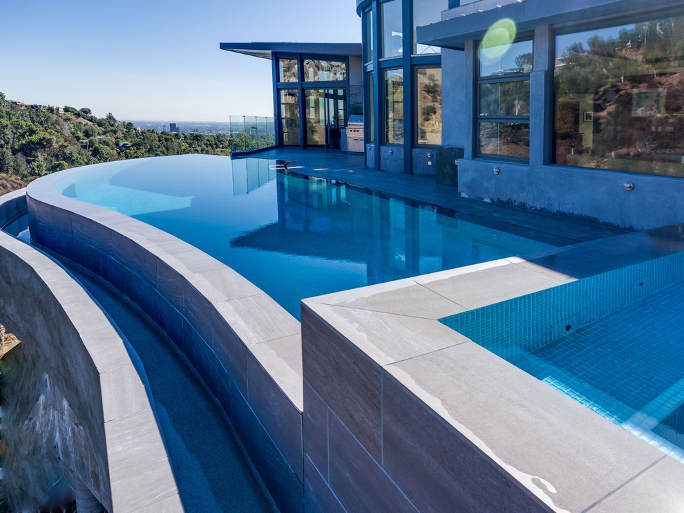 Example of a large trendy backyard custom-shaped infinity pool design in Los Angeles