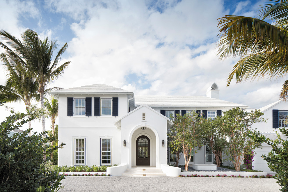 Design ideas for a beach style two-storey white house exterior in Miami with a hip roof.