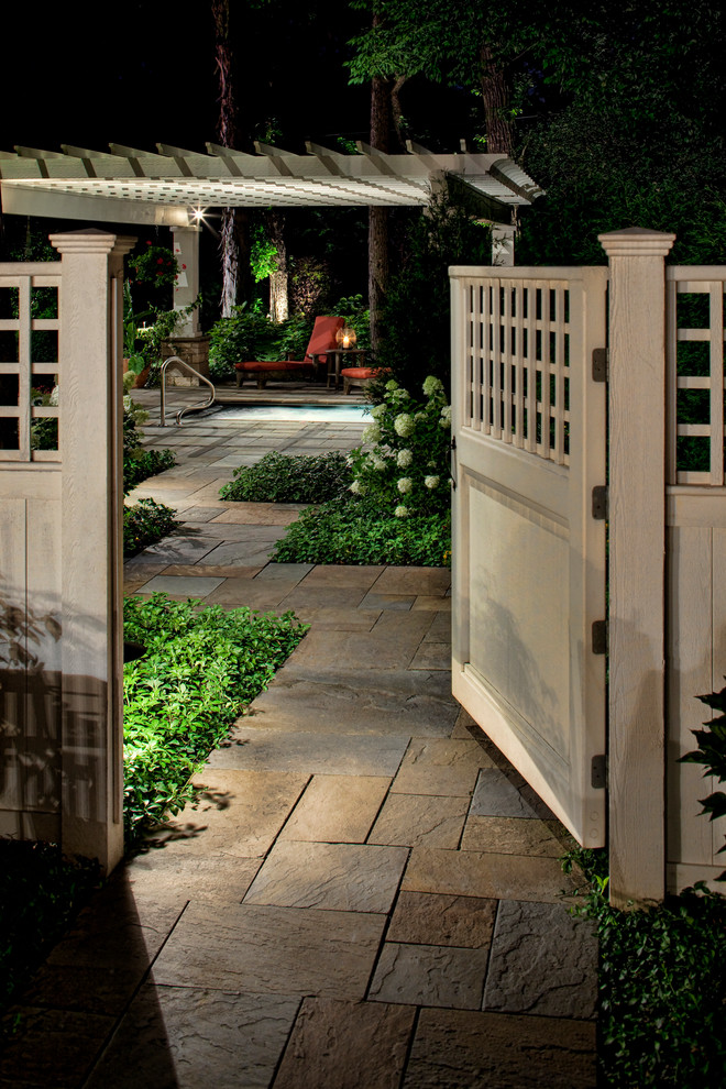 Inspiration for a large traditional backyard shaded garden for summer in Chicago with natural stone pavers and a wood fence.