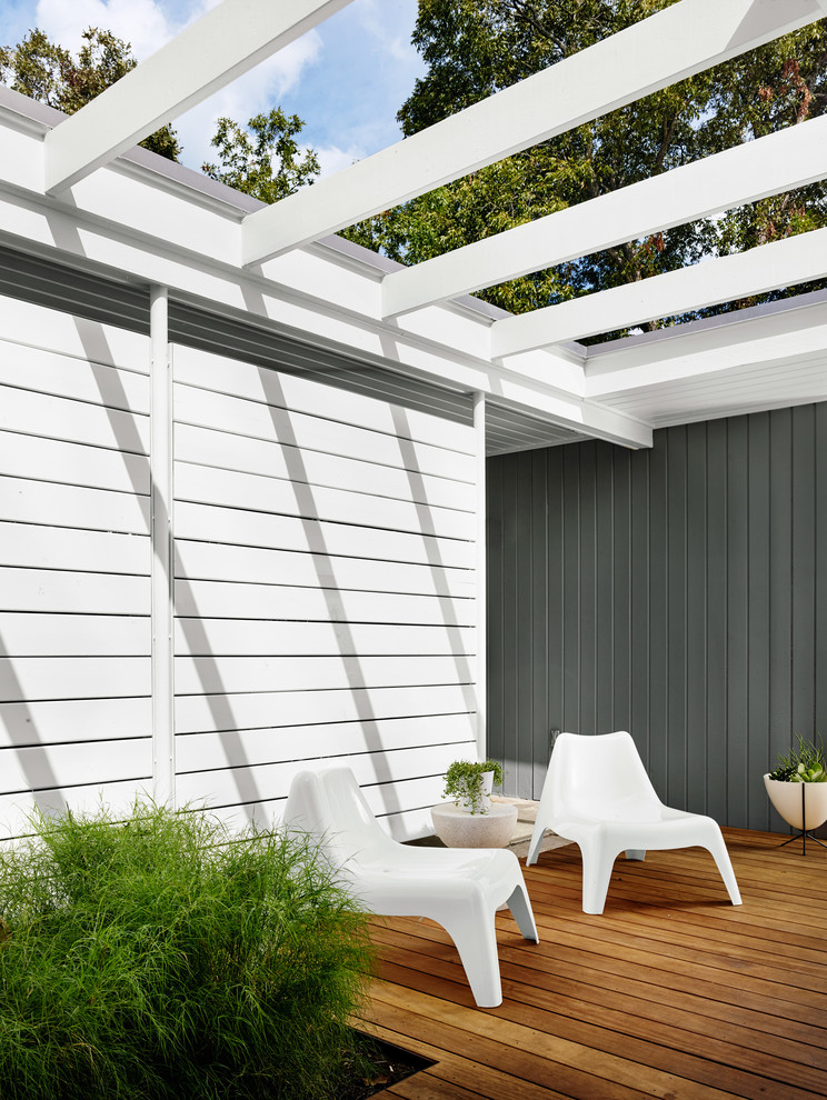 This is an example of a contemporary deck in Austin with a pergola.