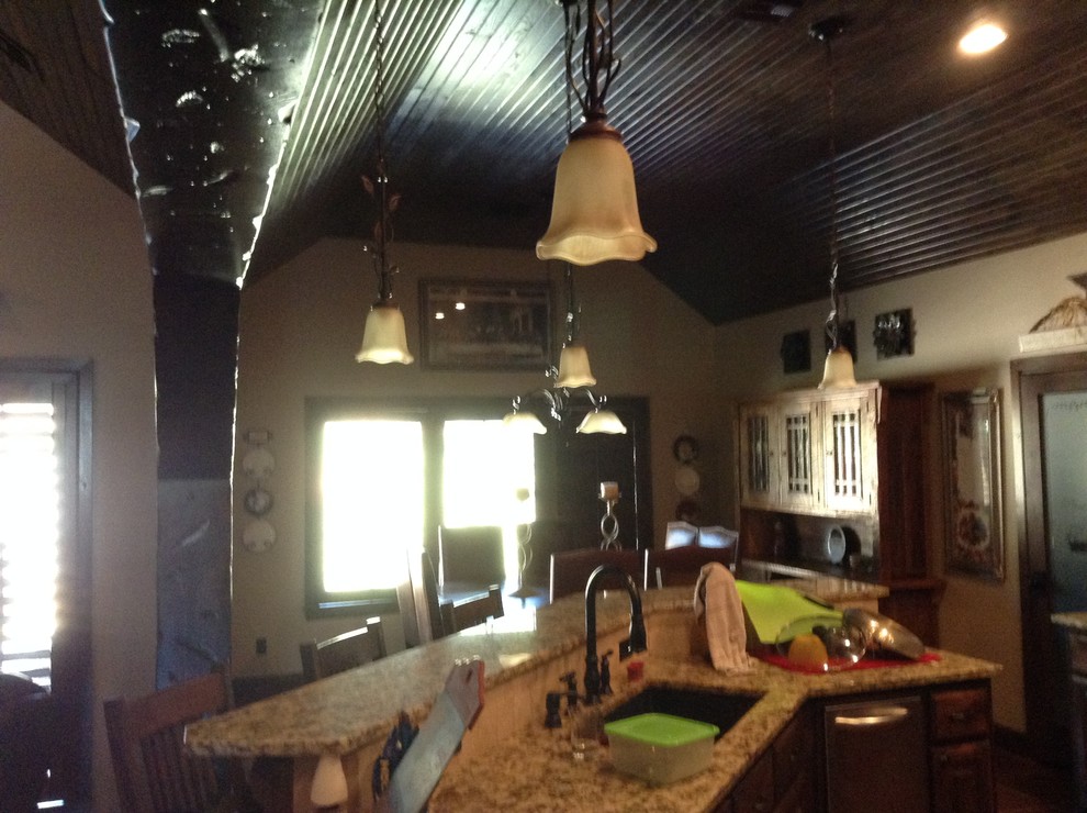 Example of a mid-sized mountain style single-wall dark wood floor open concept kitchen design with a single-bowl sink, flat-panel cabinets, medium tone wood cabinets, stainless steel appliances and an island