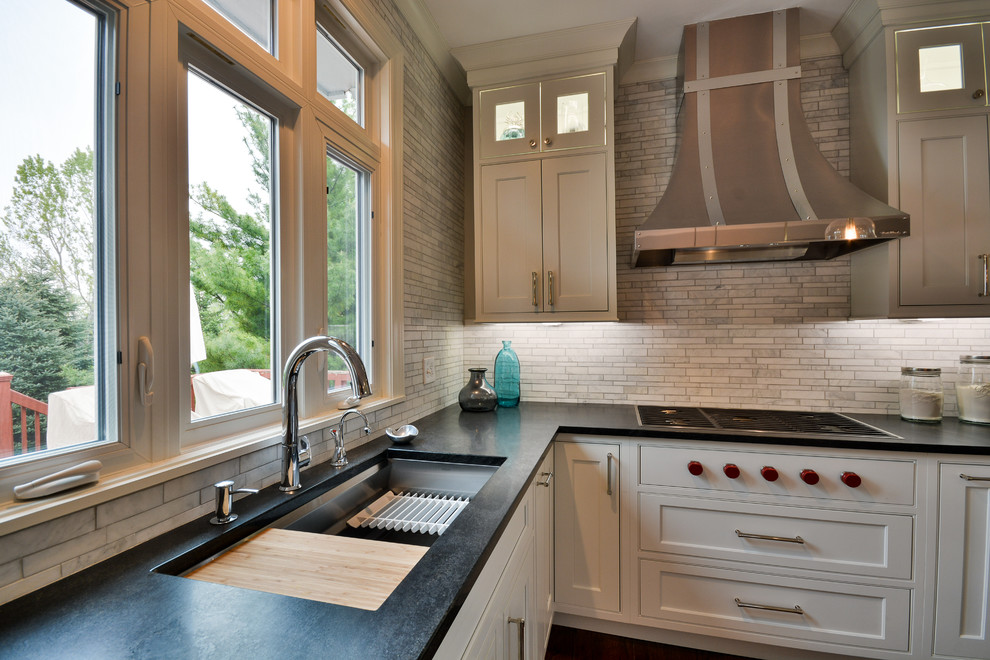 Example of a large transitional u-shaped dark wood floor and brown floor eat-in kitchen design in Chicago with an undermount sink, recessed-panel cabinets, white cabinets, soapstone countertops, gray backsplash, marble backsplash, stainless steel appliances and an island