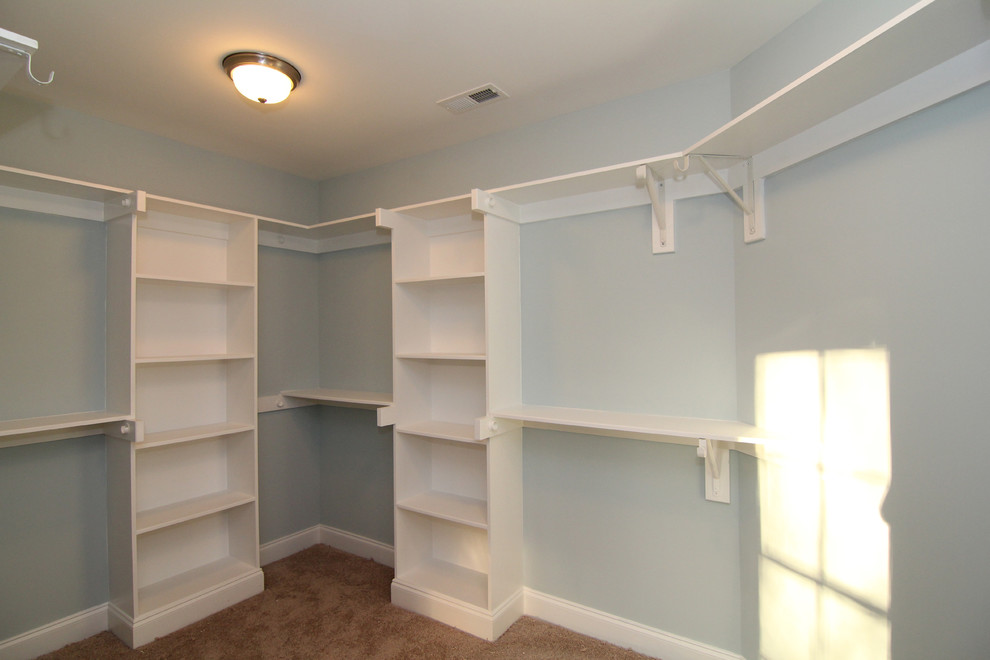 Design ideas for a large traditional gender-neutral walk-in wardrobe in Raleigh with carpet.