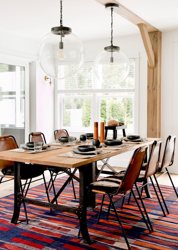 Expansive country dining room in New York with white walls, light hardwood floors and multi-coloured floor.