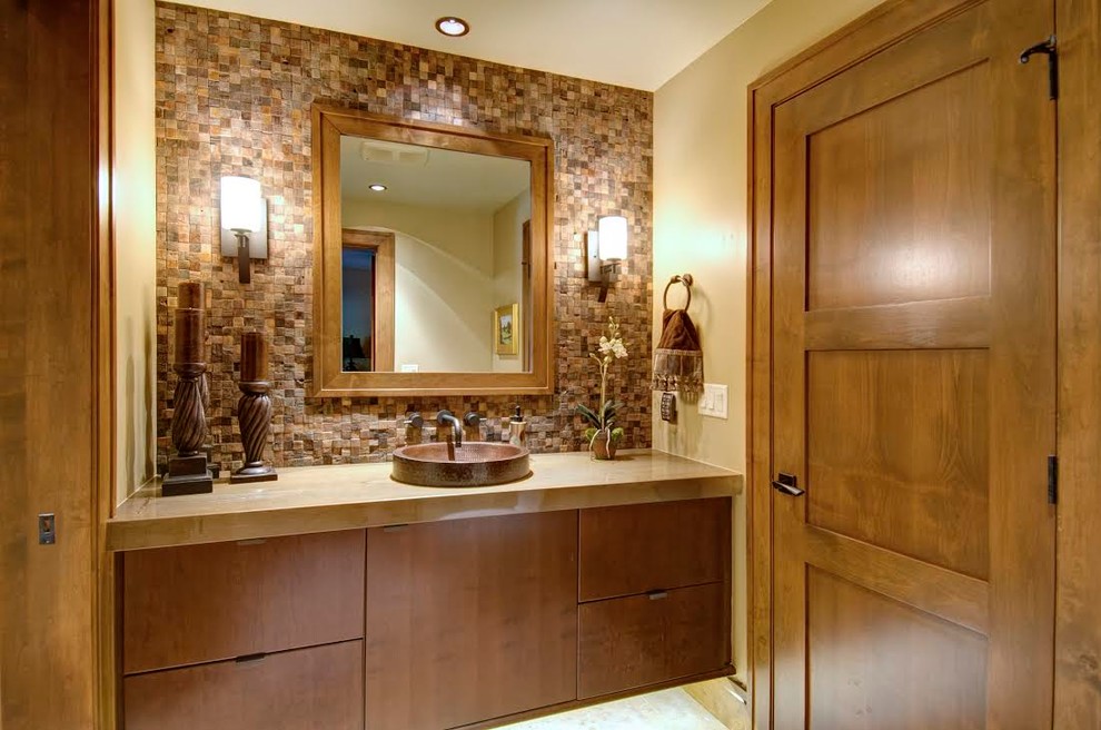 Inspiration for a mid-sized contemporary master bathroom in Denver with a drop-in sink, flat-panel cabinets, medium wood cabinets, brown tile, stone tile, beige walls, a two-piece toilet, porcelain floors and solid surface benchtops.