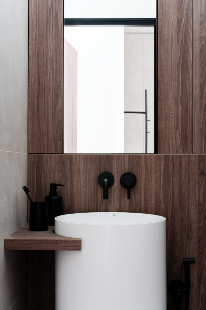 This is an example of a medium sized contemporary cloakroom in Moscow with flat-panel cabinets, dark wood cabinets, a wall mounted toilet, beige tiles, porcelain tiles, beige walls, porcelain flooring, an integrated sink and beige floors.