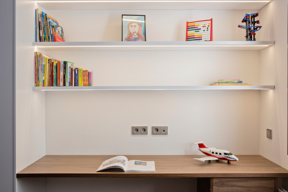 Design ideas for a large contemporary gender-neutral kids' study room for kids 4-10 years old in Barcelona with white walls, medium hardwood floors and brown floor.